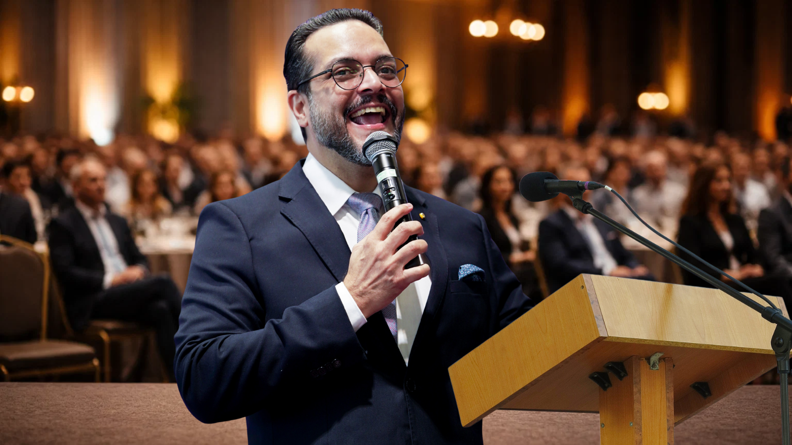 Mestre de cerimônias conduzindo evento corporativo com microfone em um auditório cheio, público ao fundo desfocado e ambiente elegante.