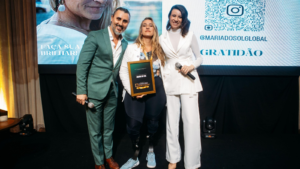 Maria do Sol no palco da Confraria dos Palcos recebendo reconhecimento ao lado de Fernando Freitas e Bruna Grah